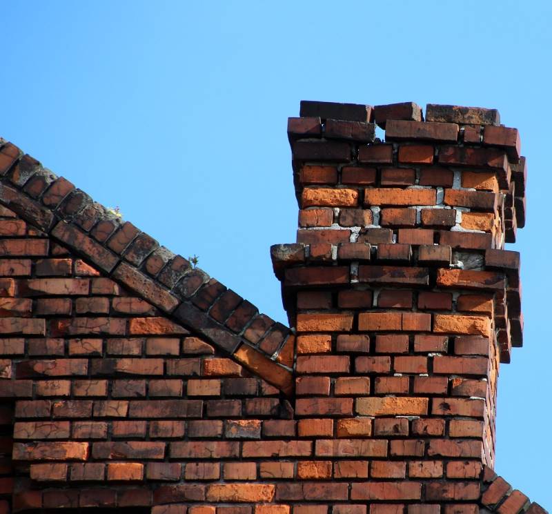 Damaged chimney on an Cone home showing cracks and missing mortar
